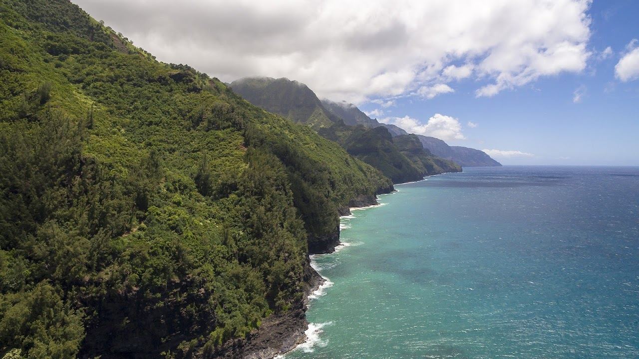 Reef fringed cove under green Napali cliffs at Kee Beach on the north shore of Kauai