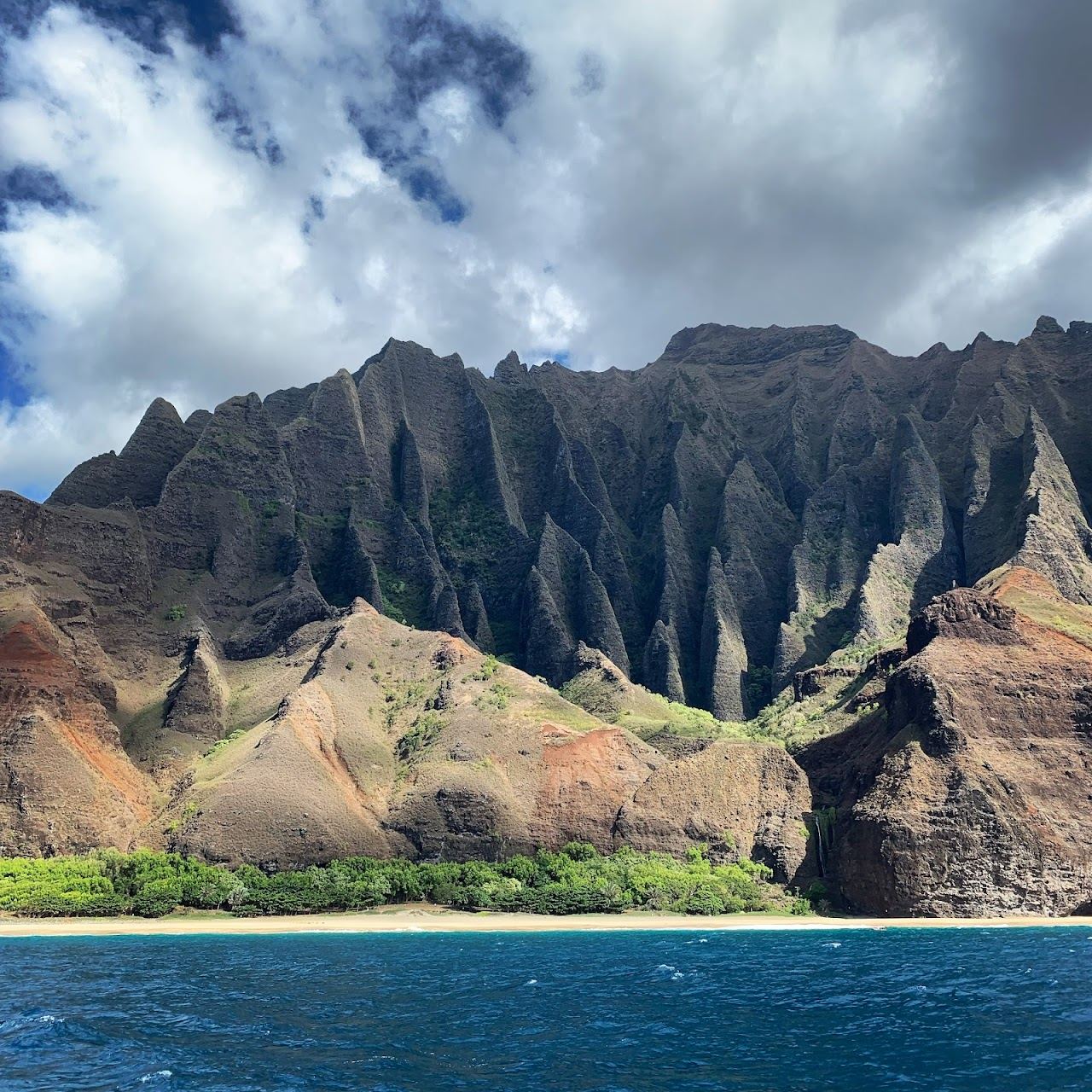Green cliffs of the Napali Coast meeting the blue Pacific on Kauai in Hawaii