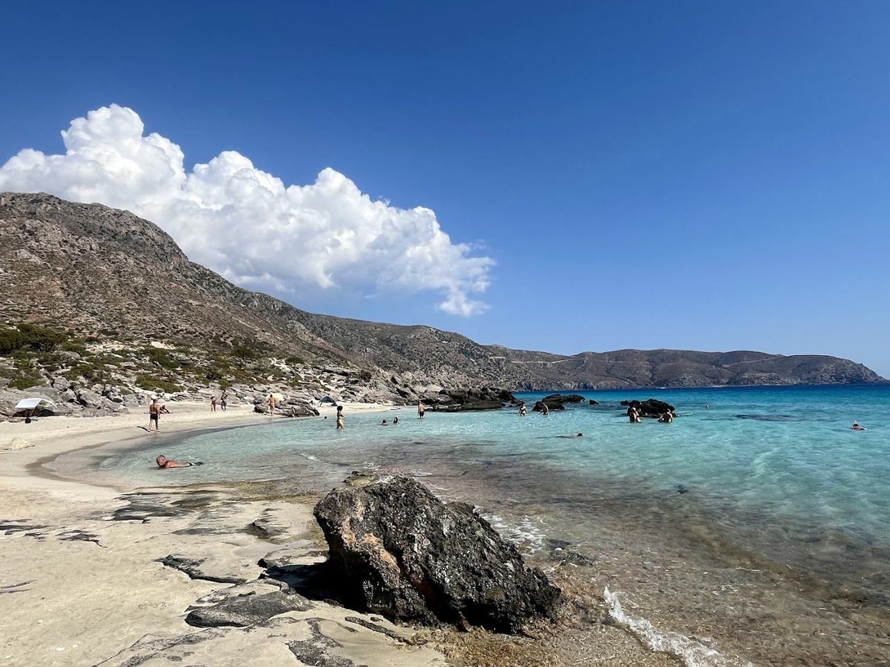 Pale sand, low juniper trees and shallow turquoise water at the wild Kedrodasos beach in west Crete