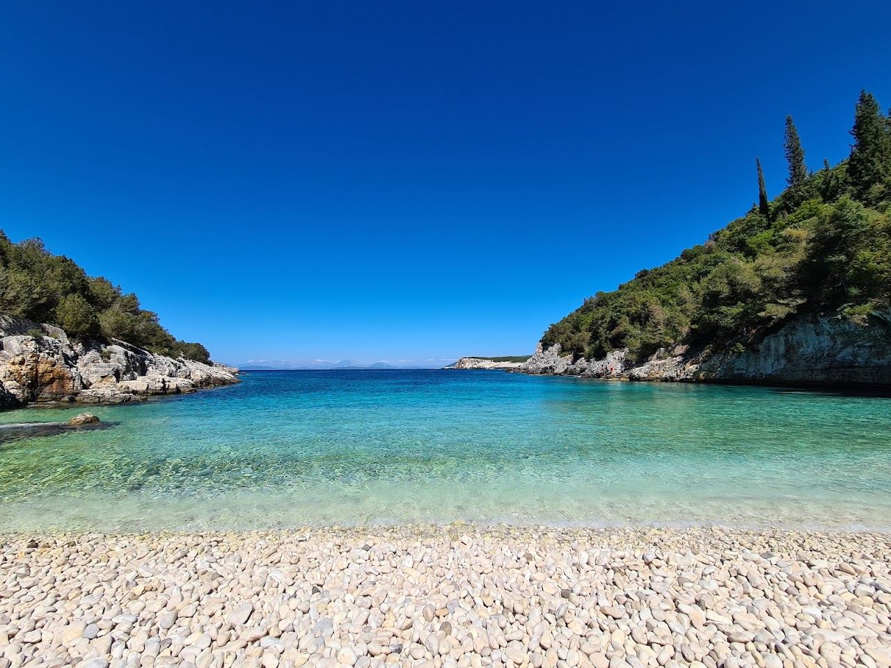 The secluded pebble cove and clear water of Dafnoudi Beach near Fiskardo in Kefalonia
