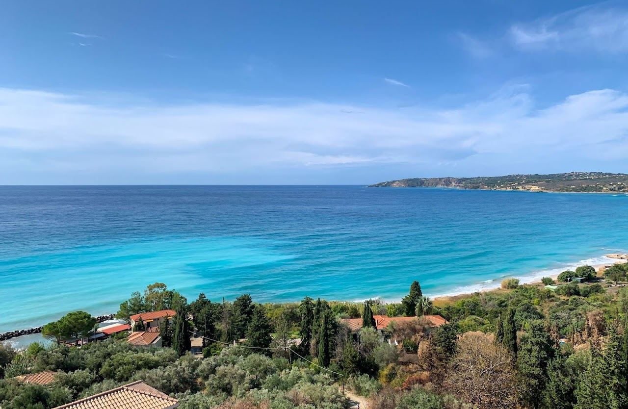 The long sand and shingle beach below the green slopes of Mount Ainos at Lourdas in southern Kefalonia