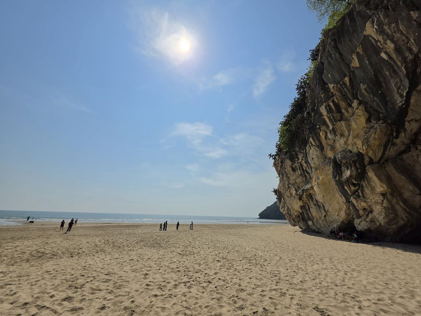 The limestone headland known as Skull Mountain rising above the quiet sand at Khao Kalok