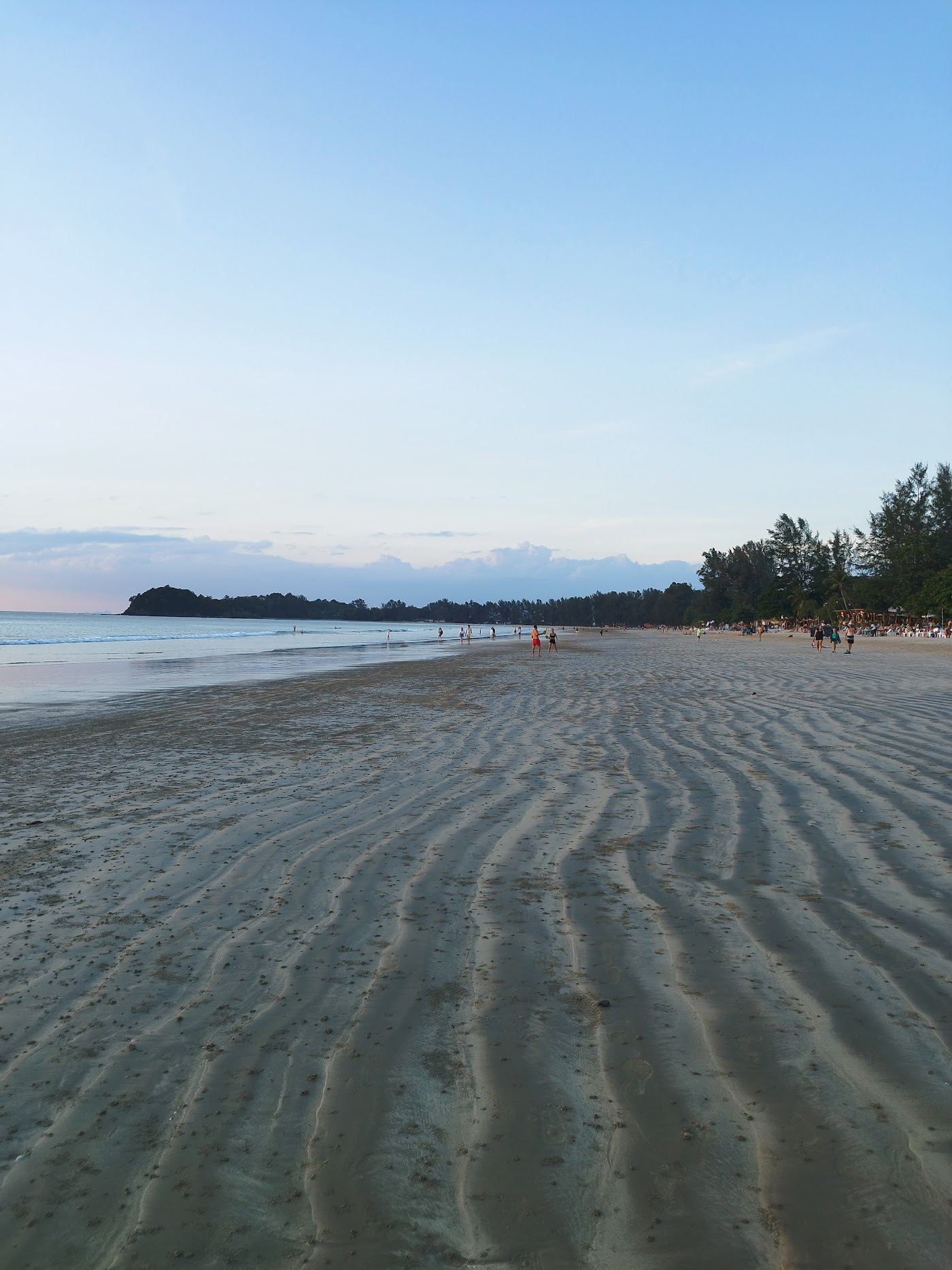 A long calm beach on the west coast of Koh Lanta with golden sand and warm sea at low tide
