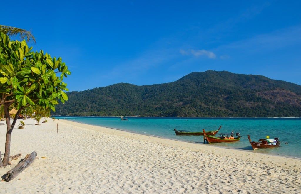 A beach bar with bean bags on the white sand of Sunrise Beach on Koh Lipe