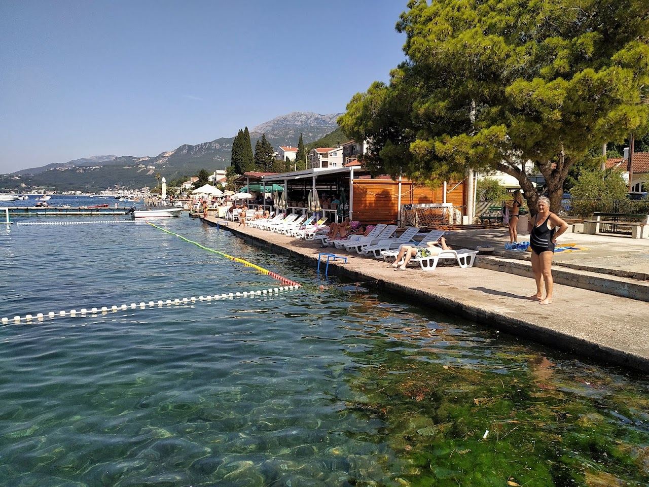 The calm water of Boka Bay at Kumbor near Herceg Novi with mountains rising behind the shoreline