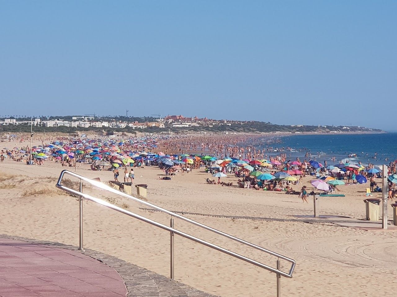 Broad golden sand and low pine cliffs along La Barrosa beach near Sancti Petri on the Costa de la Luz