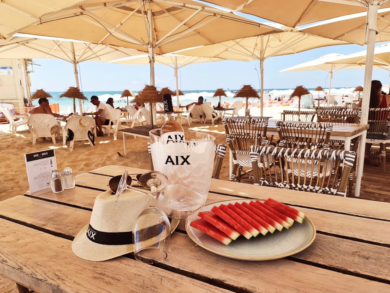 Tables and umbrellas of La La Land beach restaurant on the sand at Gordon Beach, Tel Aviv