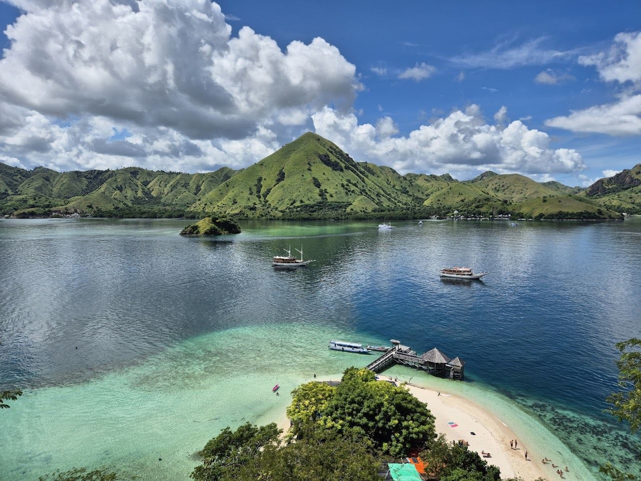 A small quiet sand cove below a green hill at Kelor Island near Labuan Bajo