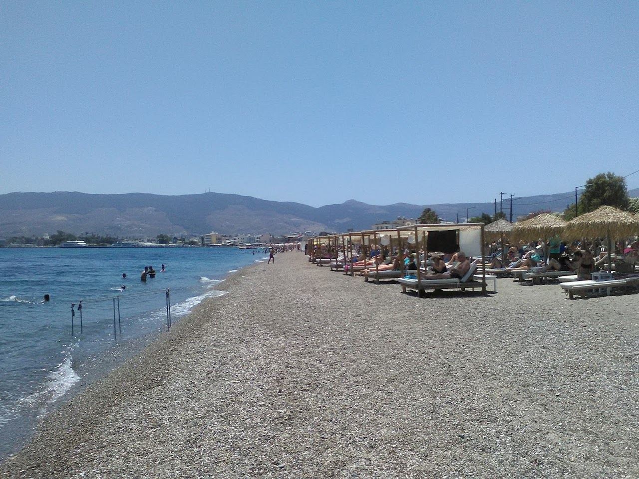 Sunbeds and umbrellas along the shallow water at Lambi Beach in Kos