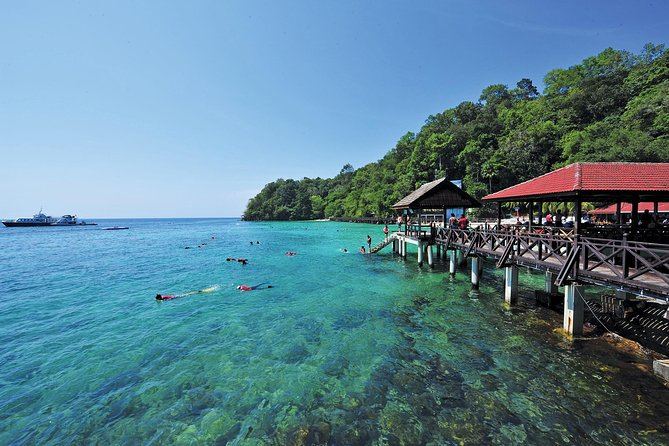 Clear shallow reef water beside the narrow sand beach at Pulau Payar marine park south of Langkawi