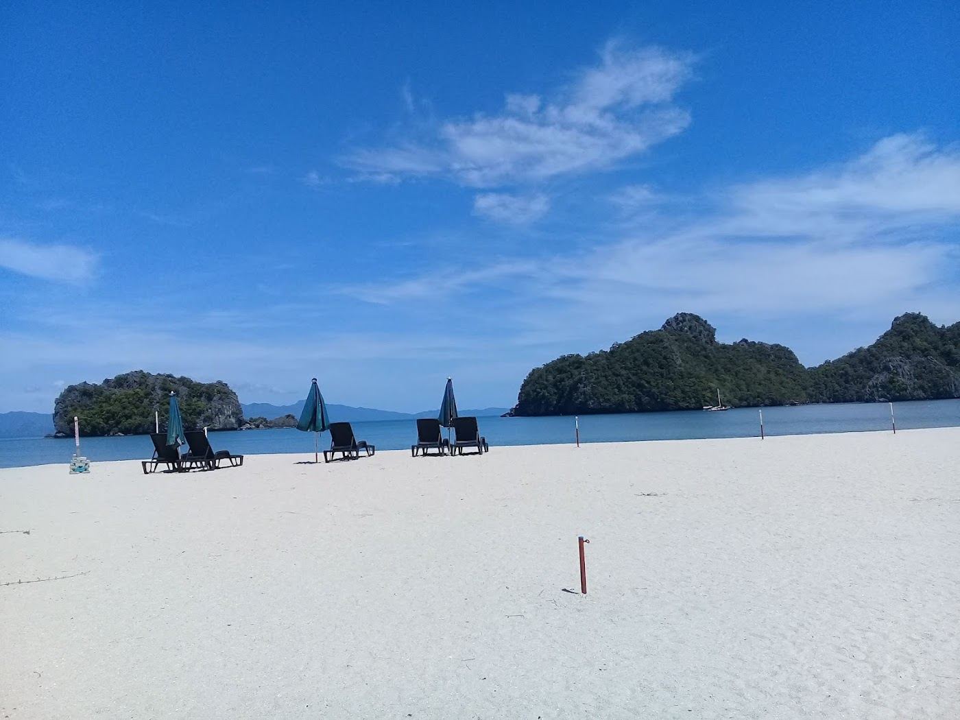 Pale sand and clear water framed by limestone karsts at Tanjung Rhu on the north coast of Langkawi