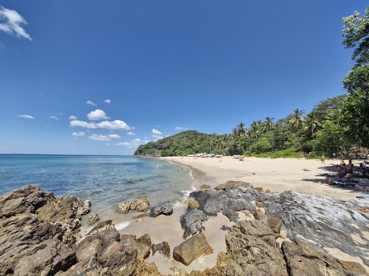 Secluded cove backed by green headland and rock at Nui Beach in the south of Koh Lanta
