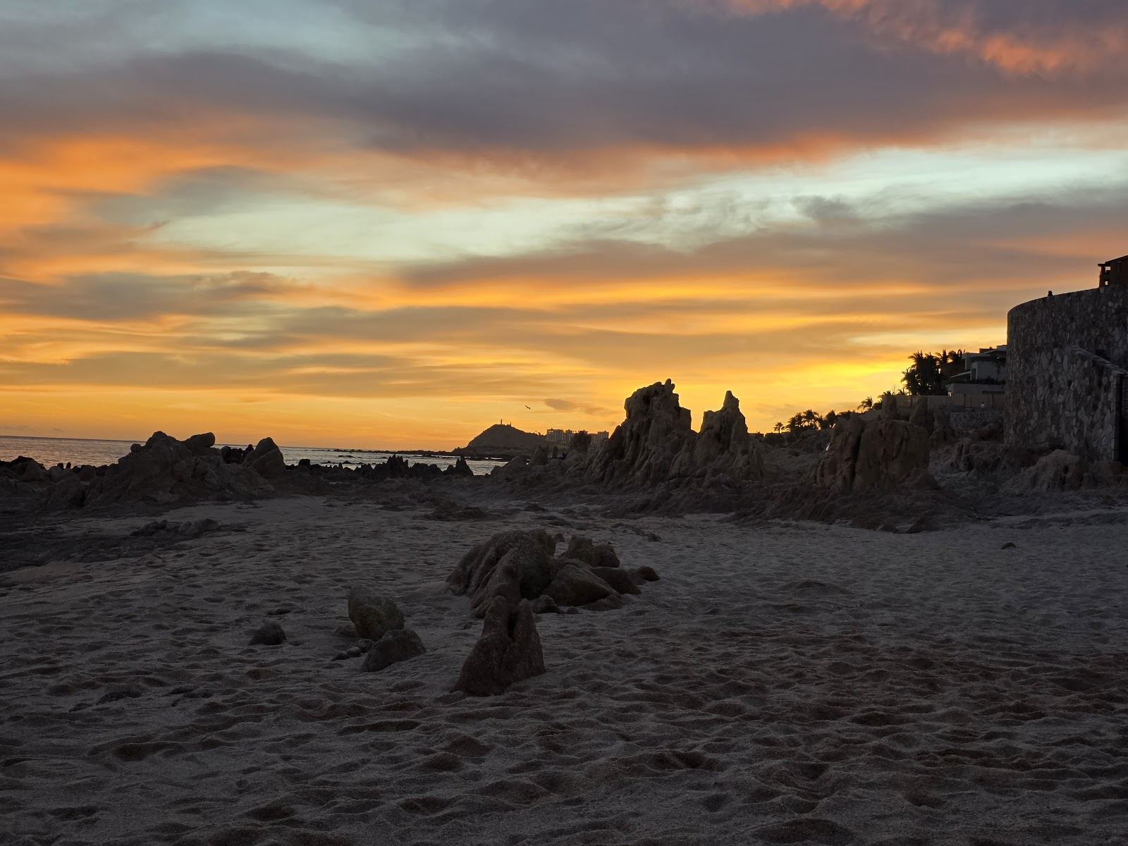Volcanic rock formations, tide pools and pale sand at the quiet cove of Playa Las Viudas in Los Cabos