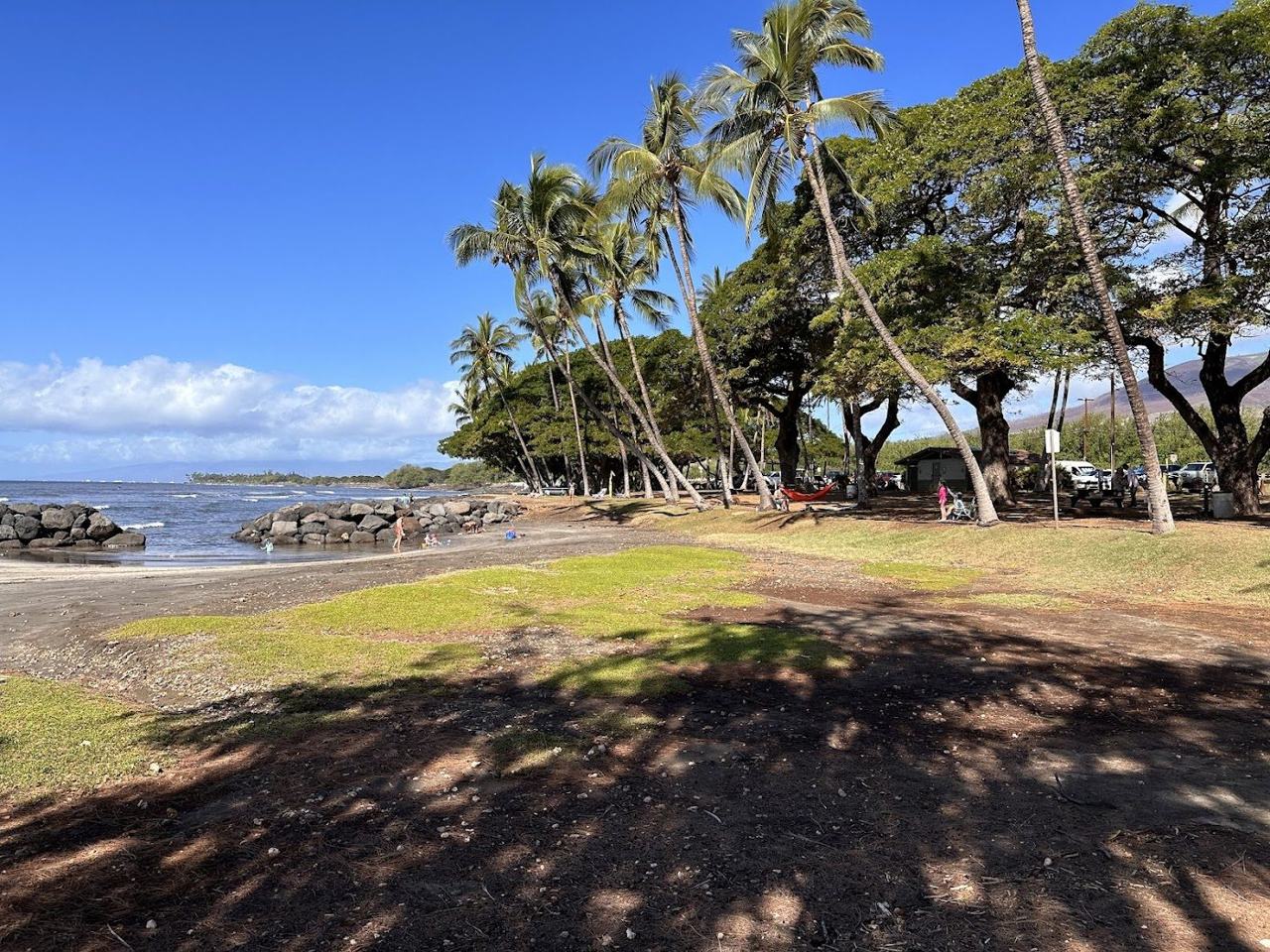 Launiupoko Beach Park West Maui a sheltered lava rock pool and small beach with palms and the West Maui mountains behind