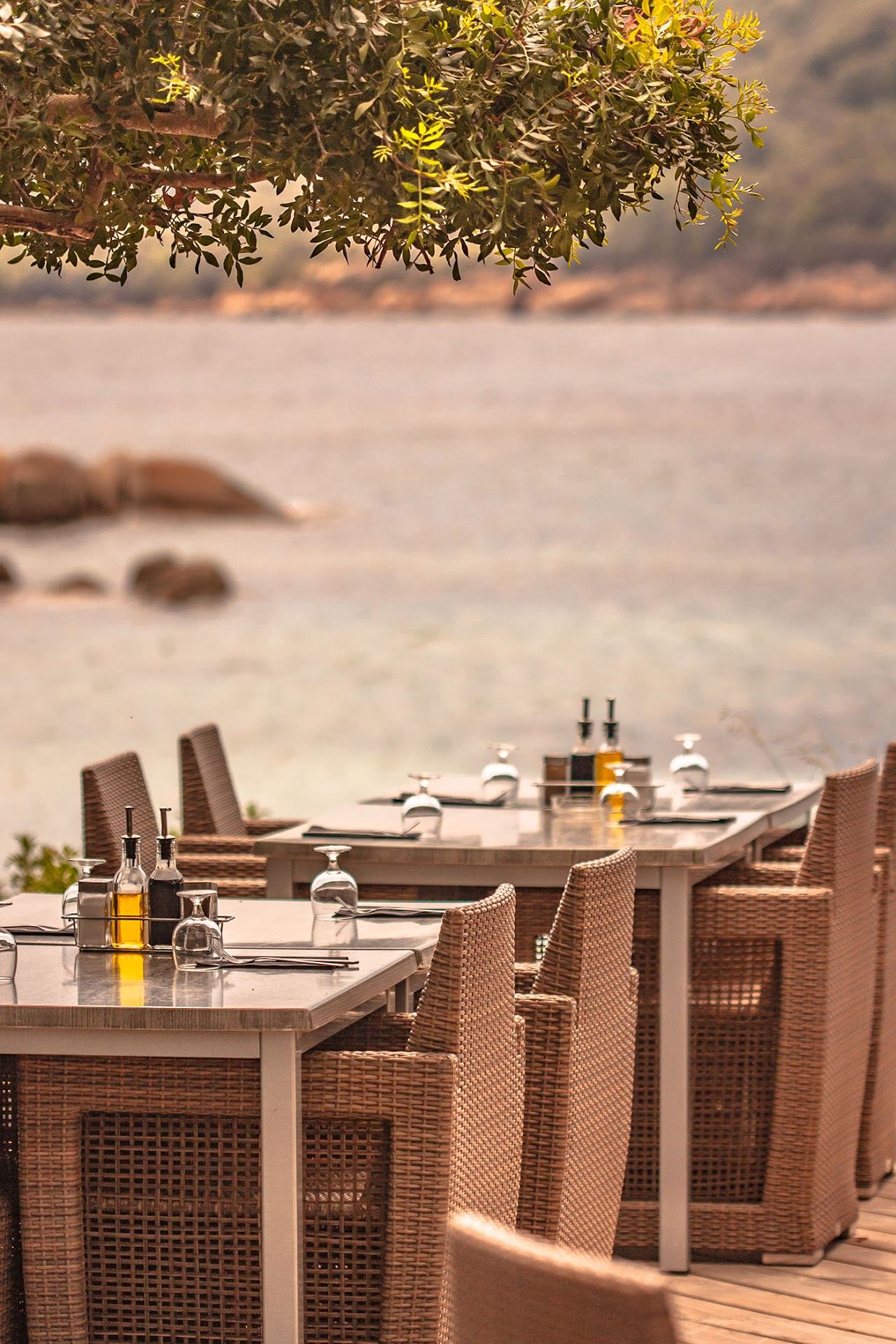 Le Fort Santa Giulia beach restaurant terrace under trees beside the calm Santa Giulia bay near Porto Vecchio, Corsica
