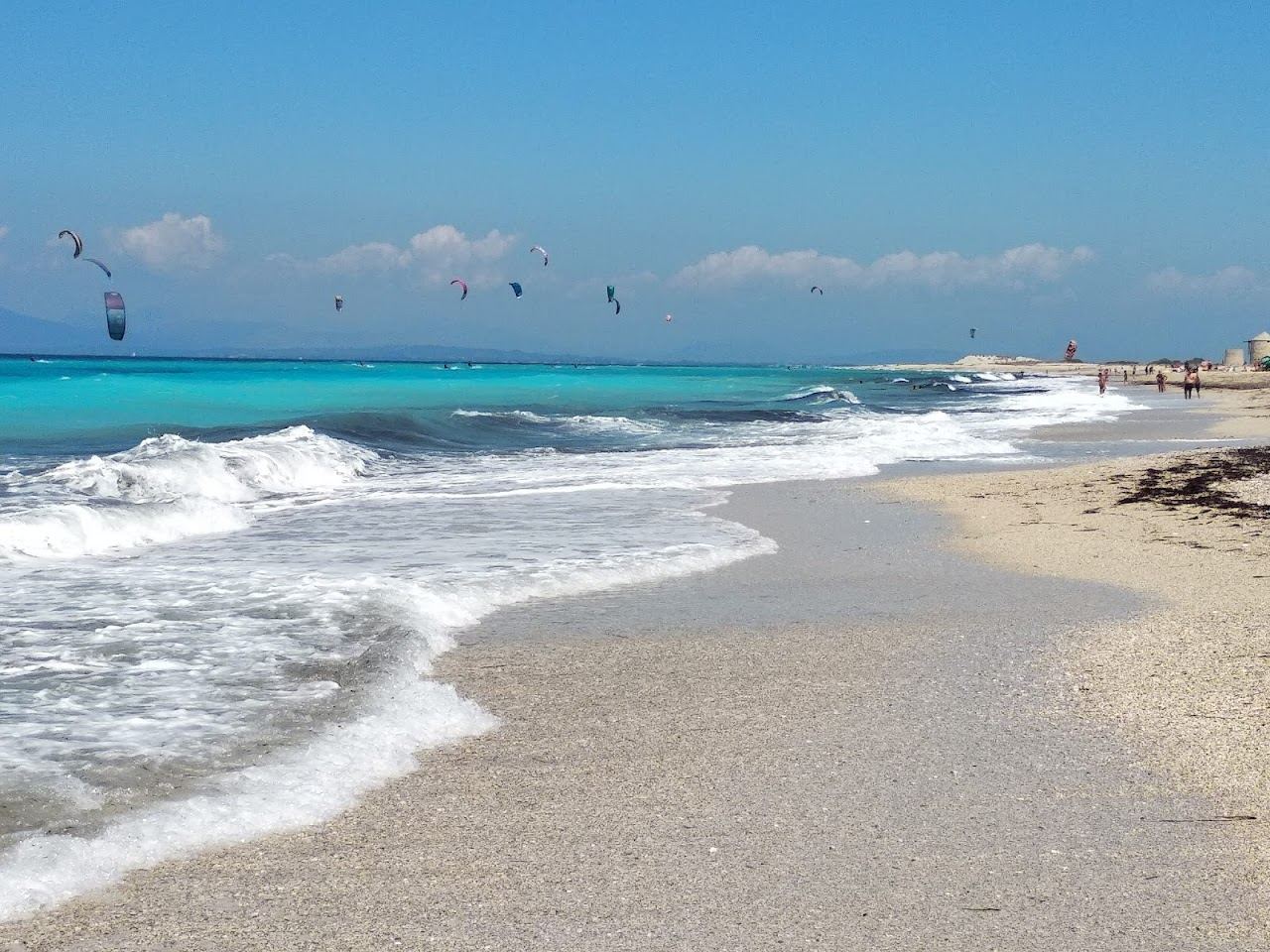 Calm clear shallows over pale sand on a sheltered Lefkada beach suited to families
