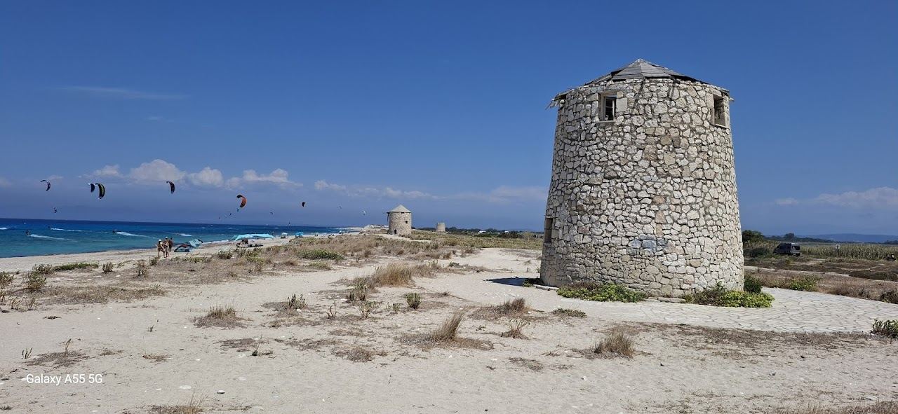 Windsurf sails on the wind across a turquoise bay on Lefkada
