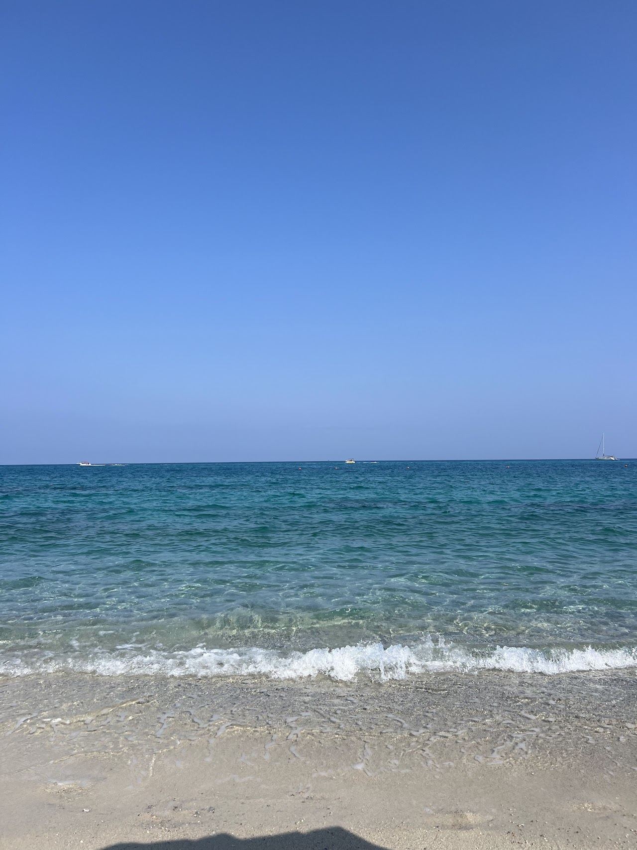 The stilt house terrace of Lido Charly standing over clear water on the Marina del Convento sand at Tropea