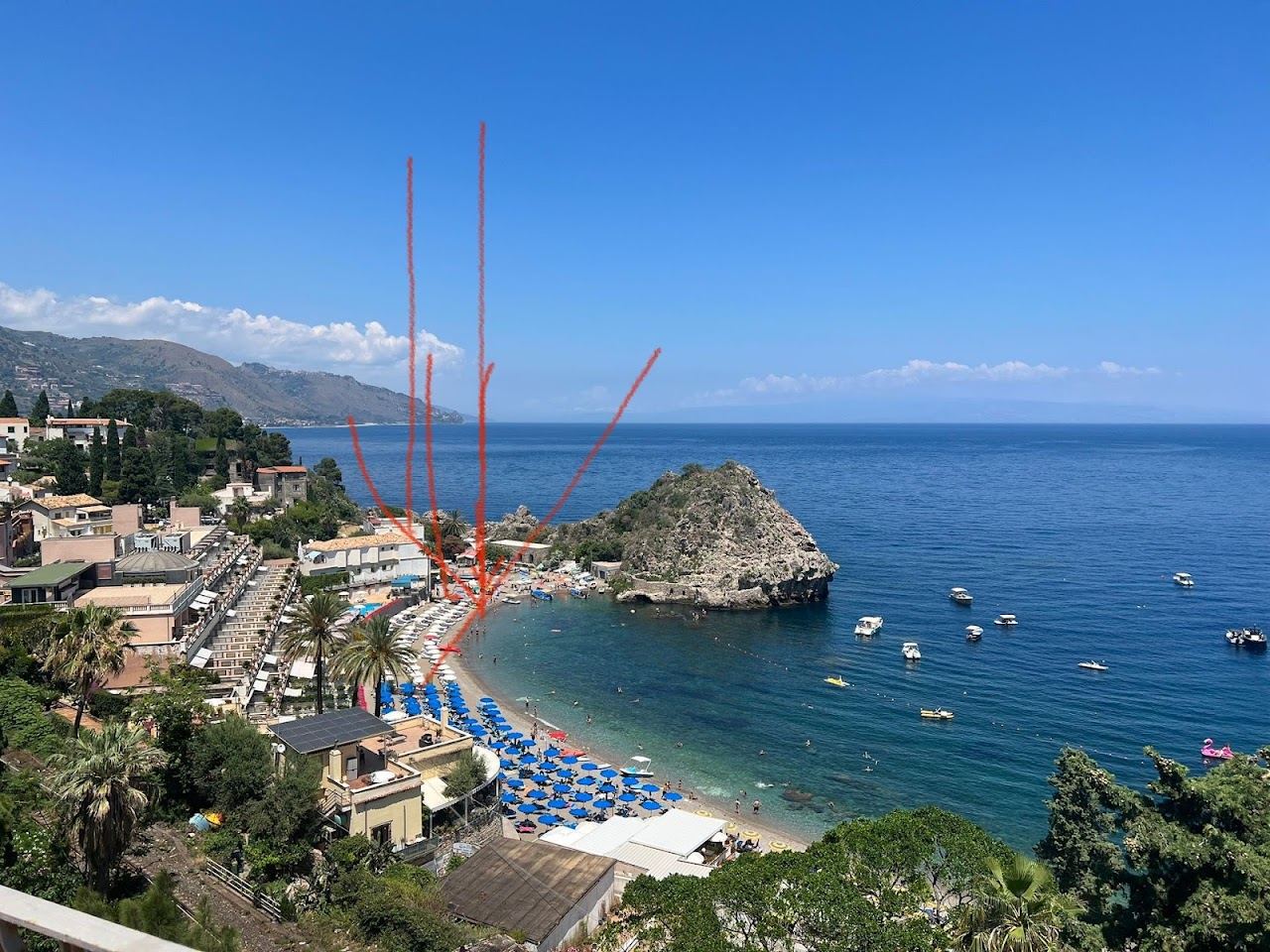 Umbrellas of Lido Il Delfino along the clear water of Mazzaro bay beneath Taormina, Sicily