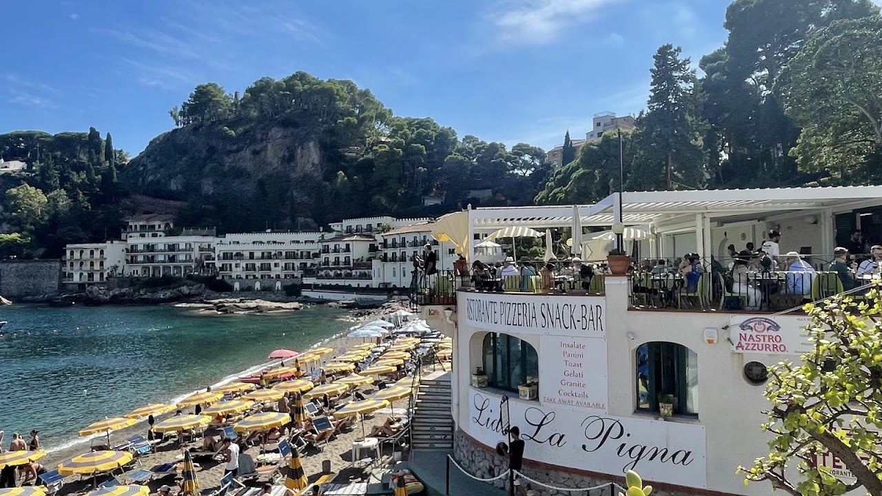 Umbrella rows and sunbeds of Lido La Pigna on the pebbles of Mazzaro bay below Taormina, Sicily