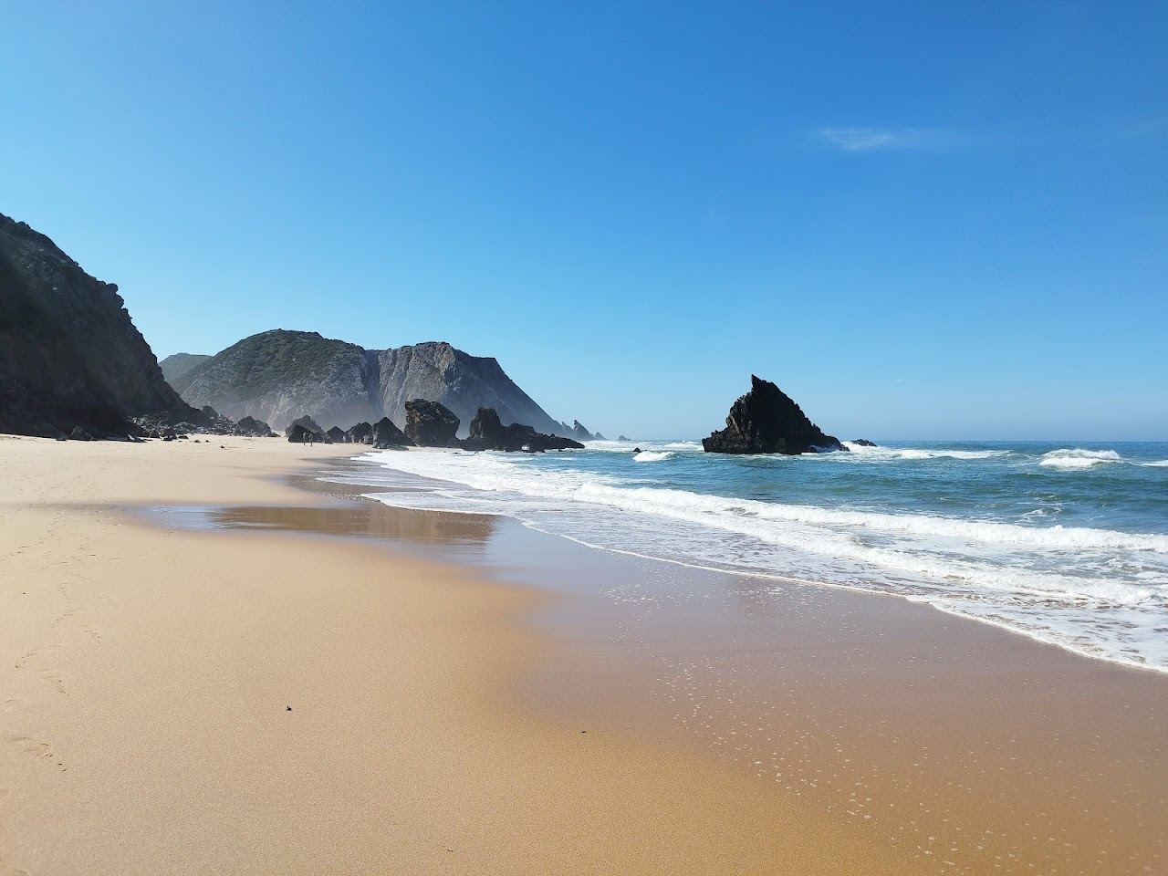 The cliff framed sand and rock arch of Praia da Adraga near Sintra