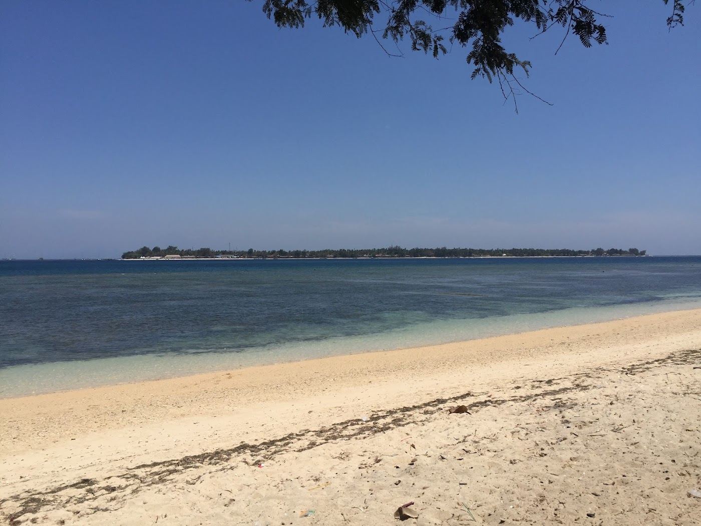 Long white sand and calm water at Sira Beach in north Lombok