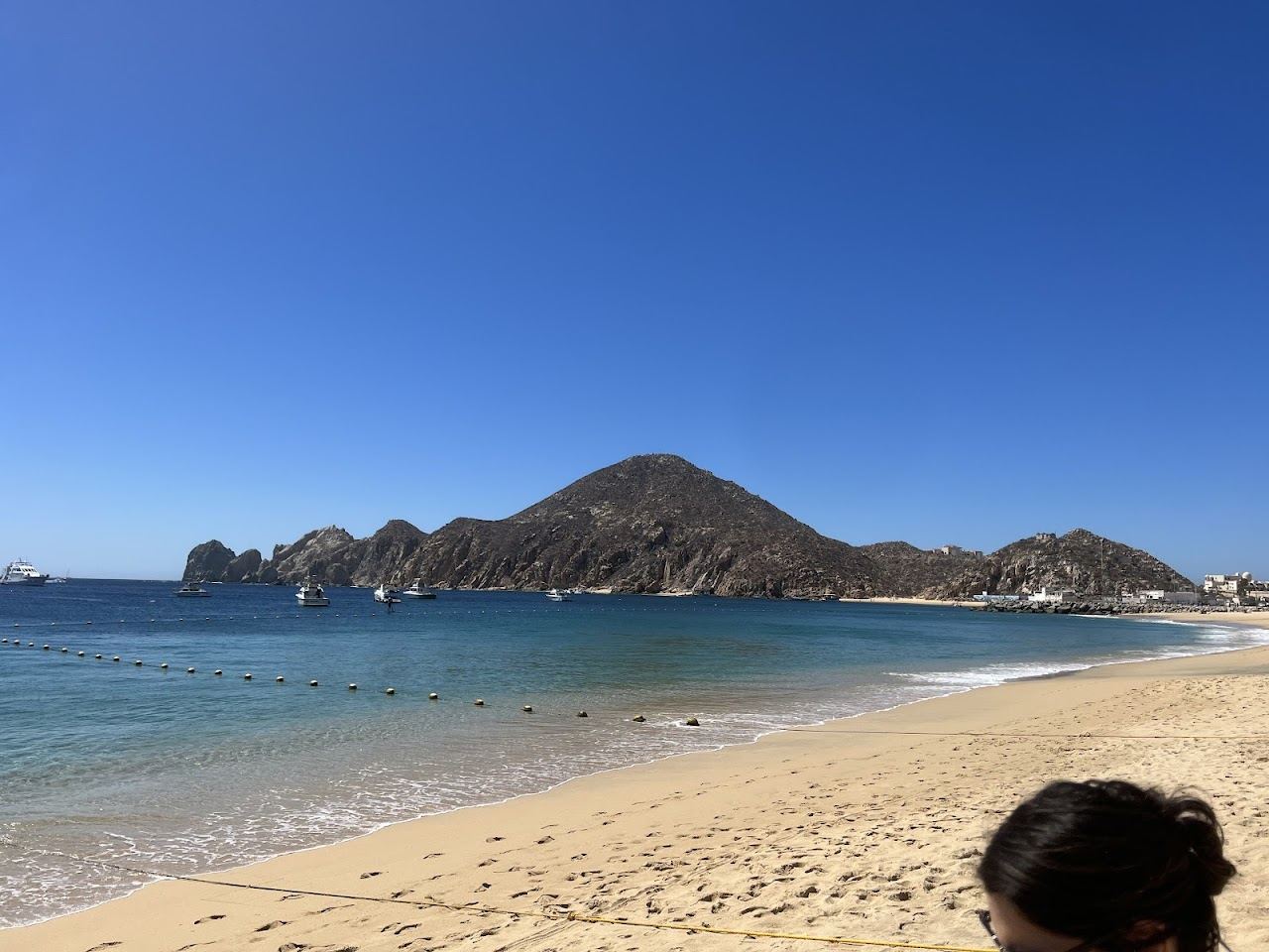 Golden sand and turquoise water at Medano Beach below the headland at Cabo San Lucas, Mexico