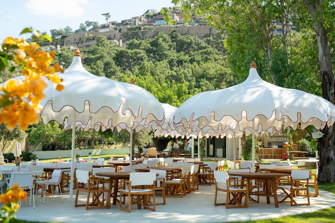 Loungers and parasols on the sandy shore of Lucca Beach at Demirbuku on the Bodrum peninsula