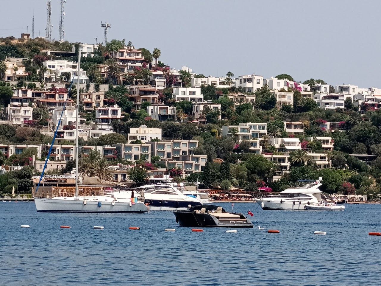 Decks and moored boats along the shoreline of Turkbuku bay at Golturkbuku, Bodrum
