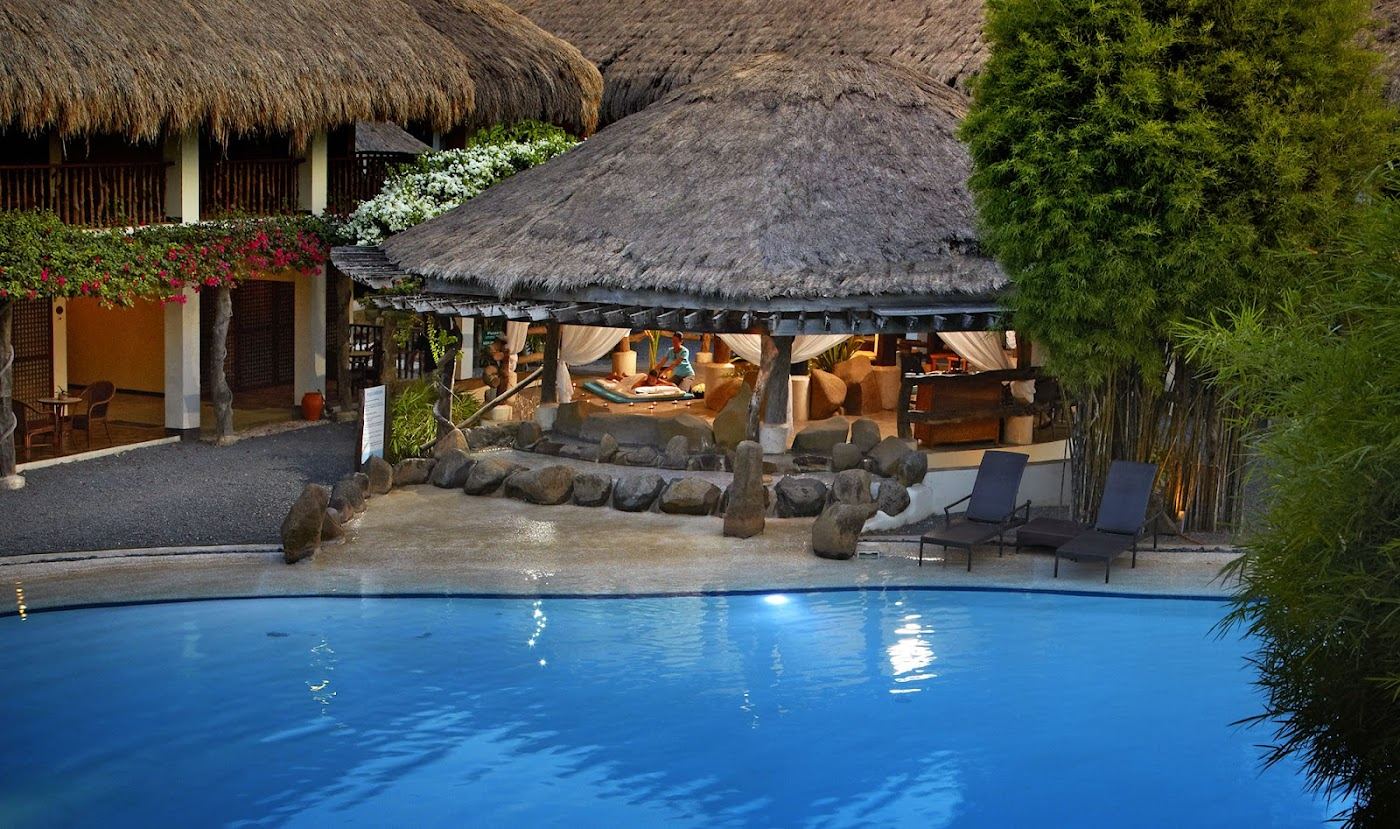 A lively resort beach front with white sand and calm channel water on Mactan