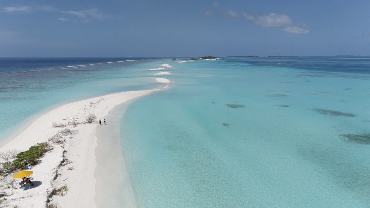 A long pale sandbar reaching into the turquoise lagoon at Dhigurah in the Maldives