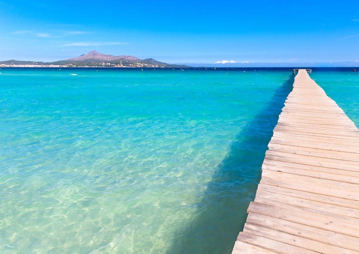 Long shallow sandy beach with calm clear water at Playa de Muro in the Bay of Alcudia Mallorca