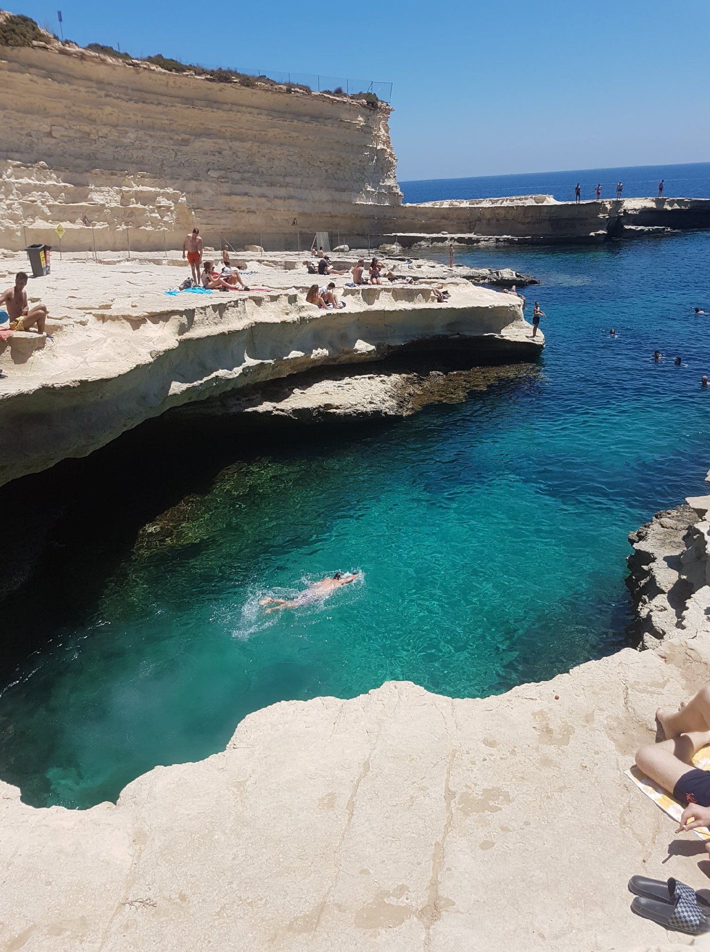 Clear deep water and flat limestone rock at St Peter's Pool in southeast Malta