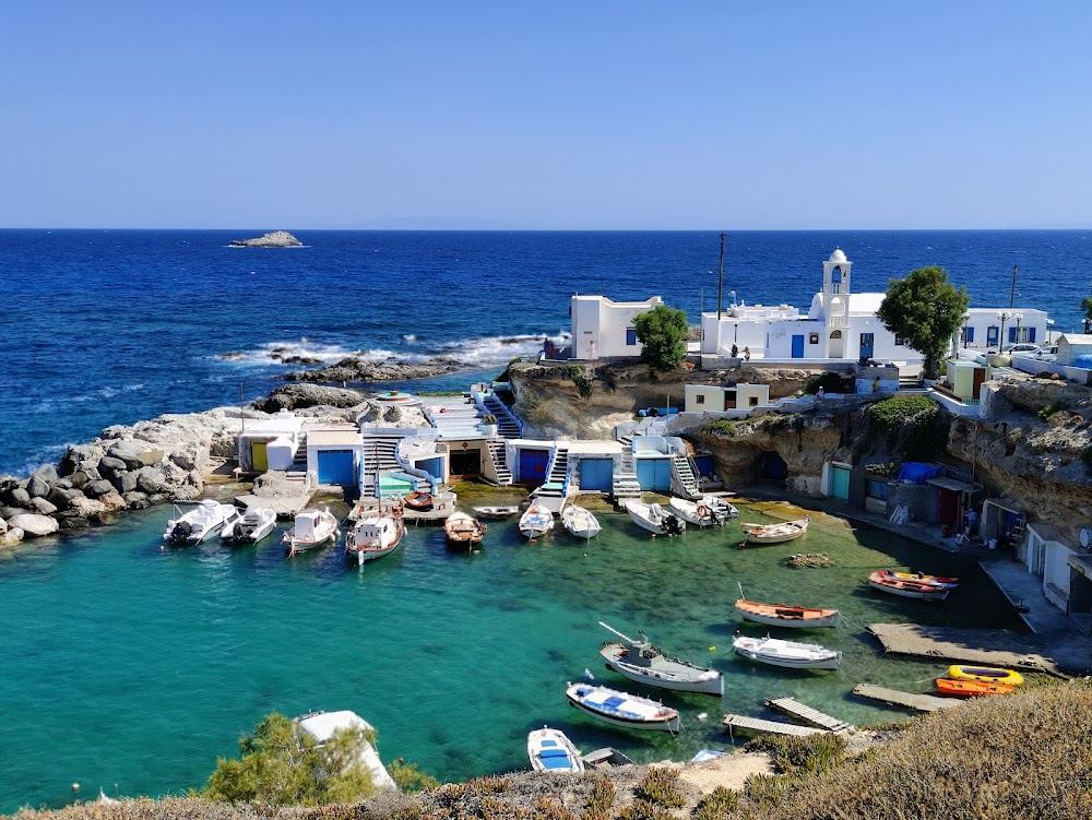 Whitewashed boat houses with painted doors around the small harbour of Mandrakia on the north coast of Milos