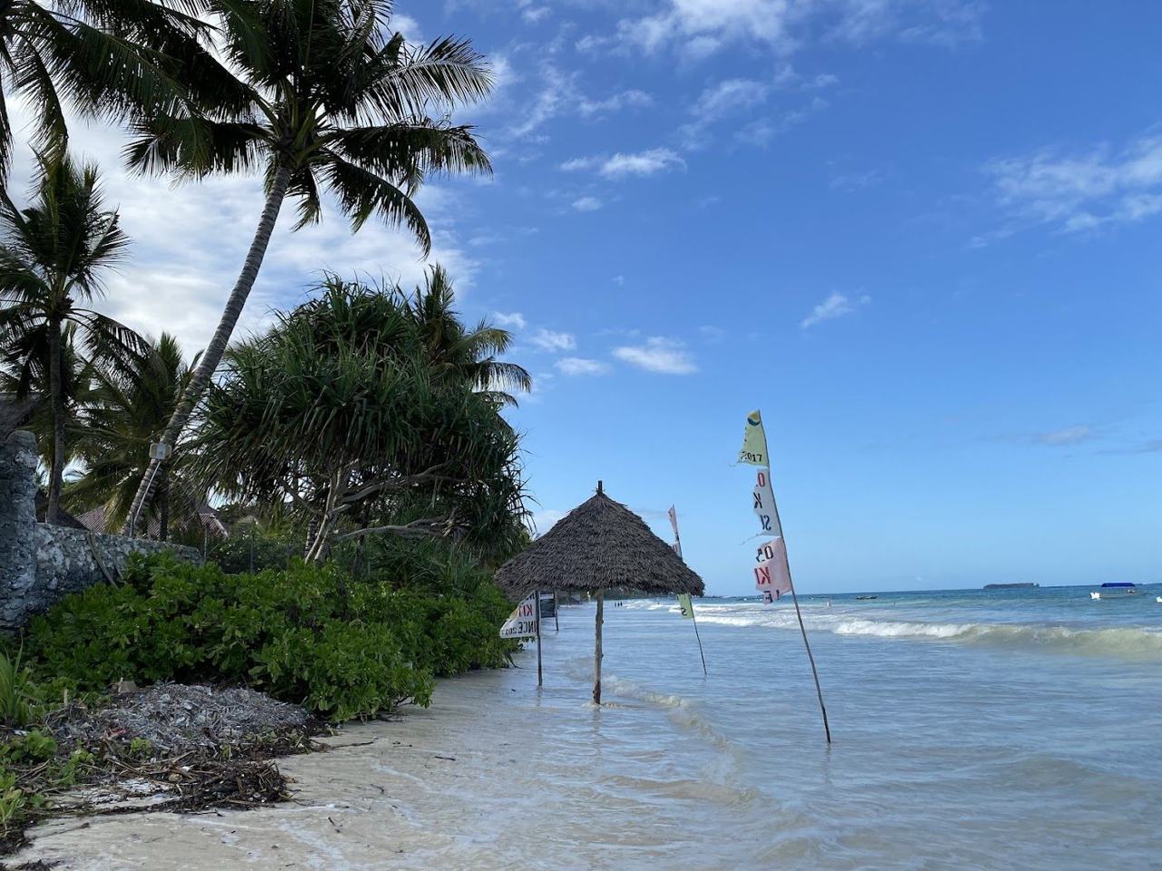 Long pale beach, turquoise lagoon and fishing boats at Matemwe on the north east coast of Zanzibar facing Mnemba Atoll