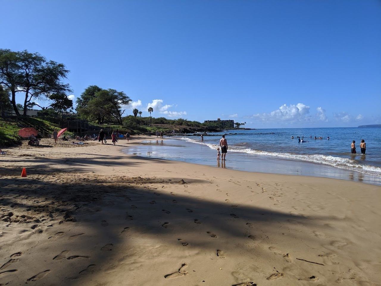 Calm shallow water and golden sand at a Kihei beach park on the sunny south coast of Maui Hawaii
