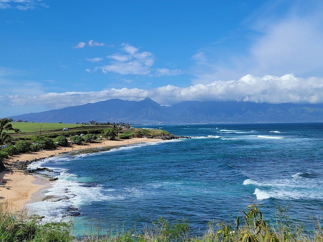 A windsurfer riding strong wind and swell off the reef at Hookipa Beach on the north shore of Maui Hawaii