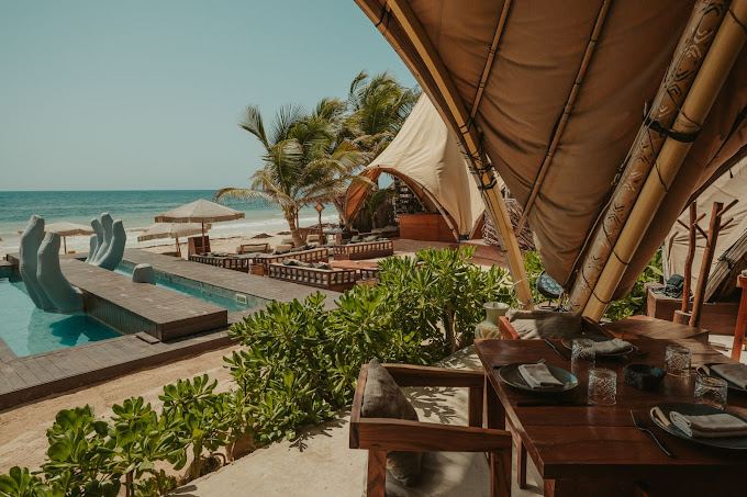 Carved wood and beach setting at Vagalume in Tulum
