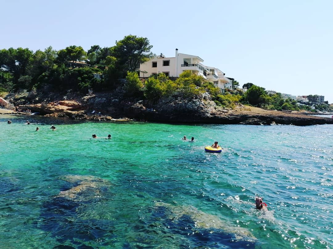 Rocky low cliffs and clear water of the Cala Blava coast on the Bay of Palma near Llucmajor in Mallorca