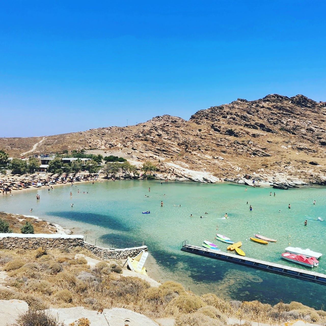 Emerald shallows and rocky headlands around the cove at Monastiri beach on Paros