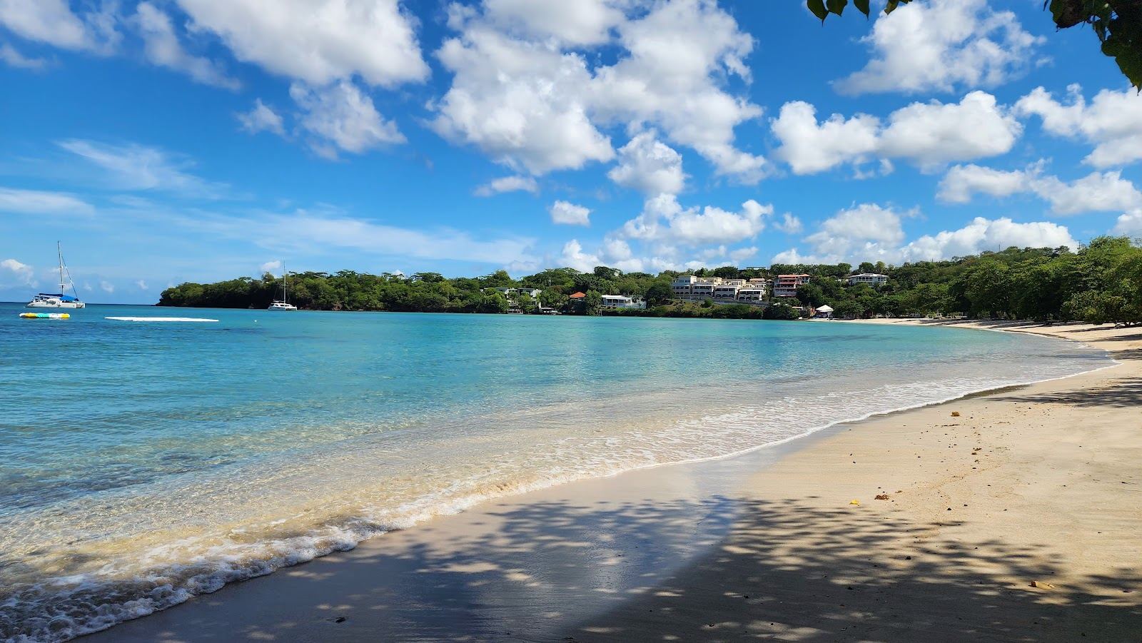 Calm turquoise water and pale sand in the sheltered cove of Morne Rouge Beach near Grand Anse in Grenada