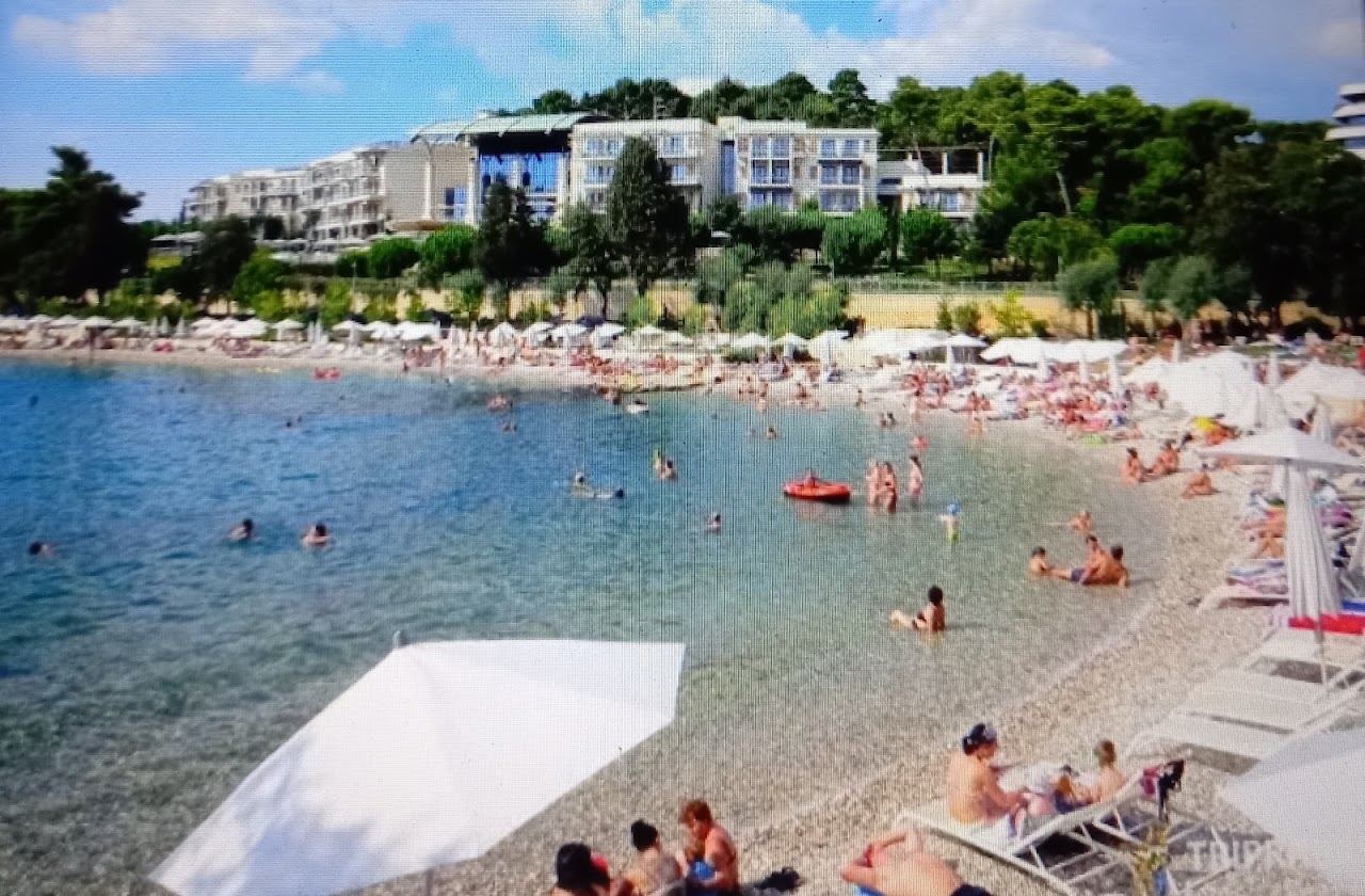 Clear water and the landscaped pebble terraces of Mulini Beach in Rovinj