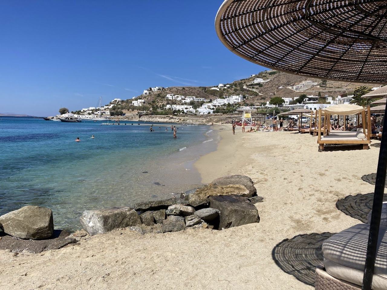 Golden sunset light over the calm cove at Agios Ioannis beach on Mykonos