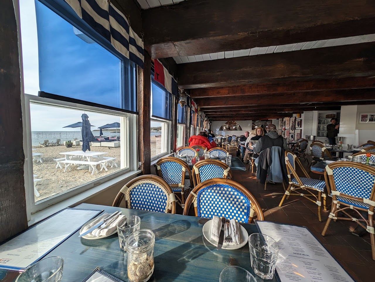 Tables and umbrellas on the private bay sand at Navy Beach restaurant in Montauk
