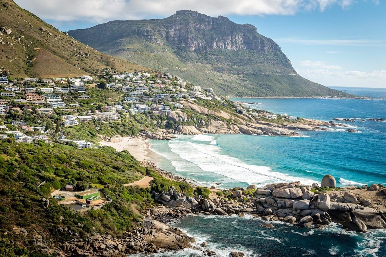 A sheltered cove of pale sand framed by granite boulders on the Atlantic side of Cape Town