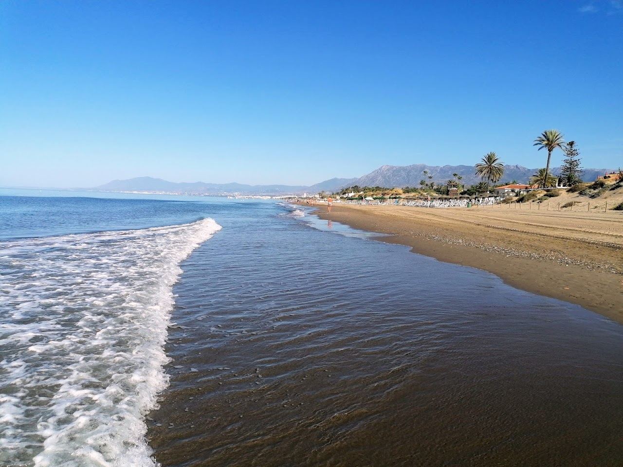 Wide golden sand and calm sea along Elviria beach east of Marbella