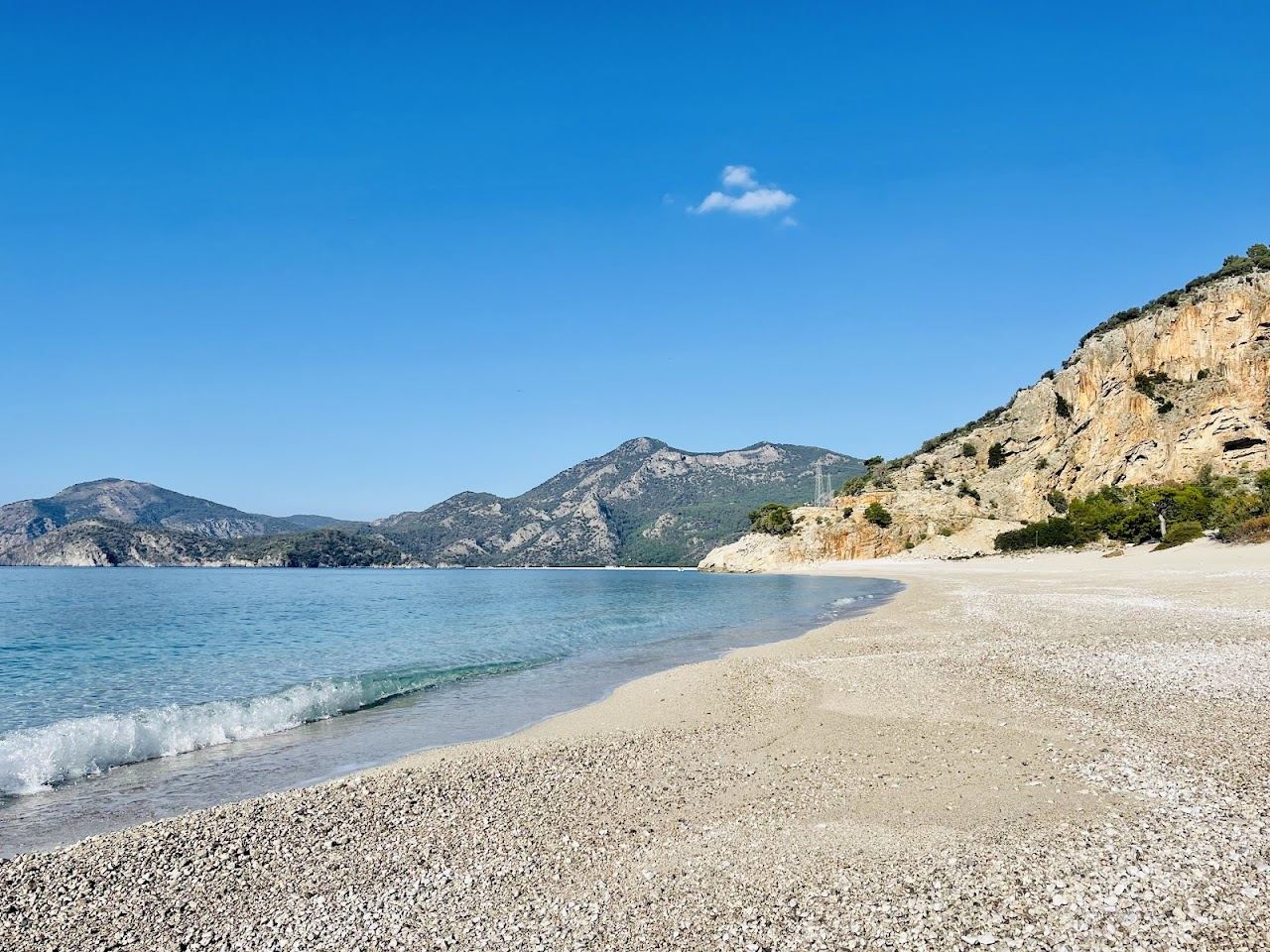 Clear turquoise water and pine backed hills at Kidrak beach near Oludeniz on the Turquoise Coast