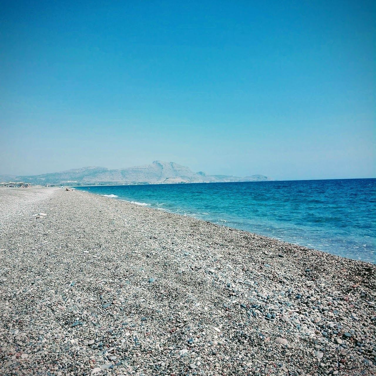 Long calm shingle and sand shoreline of Kalathos beach on the sheltered east coast of Rhodes north of Lindos