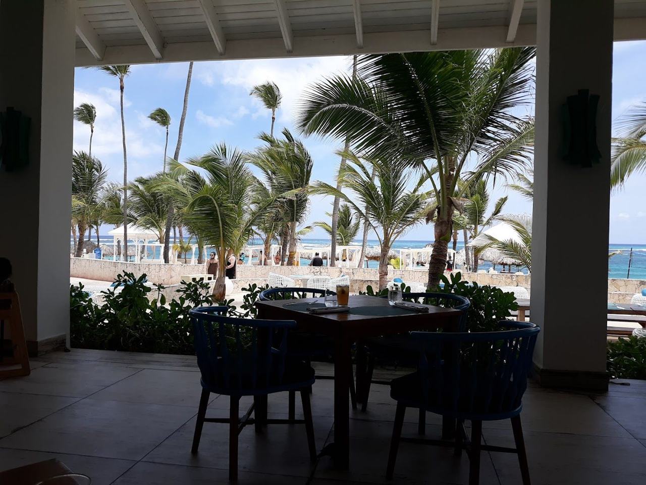 A swim up suite opening onto a pool behind a long palm backed Caribbean beach