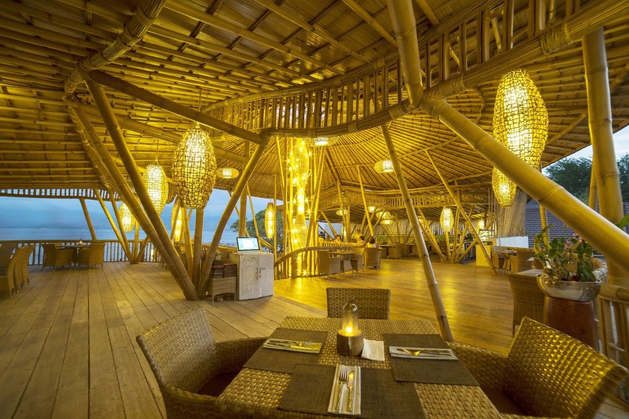 The curved bamboo pavilion of Pearl Beach Lounge on the east shore of Gili Trawangan with tables near the sand